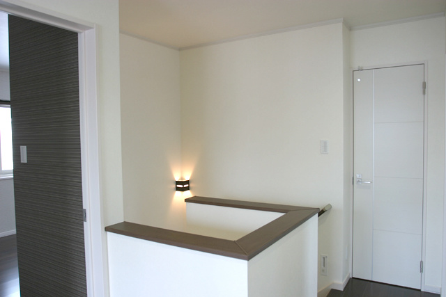 階段ホール： シンプルですが、 ドアのデザインやブラケットライトが アクセントになっています。