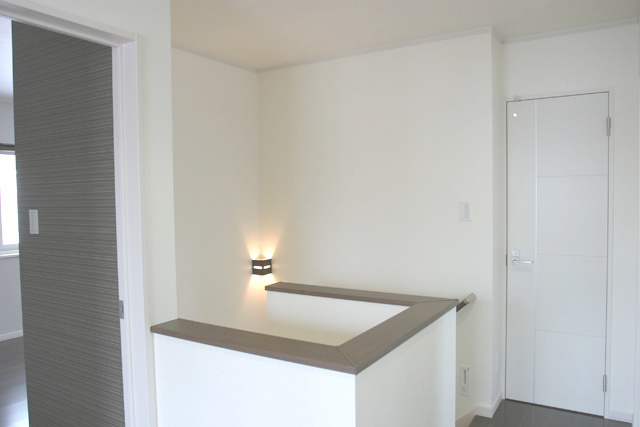 階段ホール： シンプルですが、 ドアのデザインやブラケットライトが アクセントになっています。