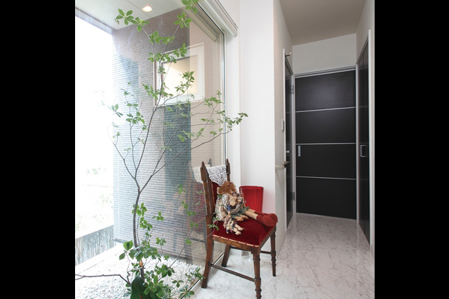 廊下： 玄関からユーティリティ、 キッチンへと続く廊下。 左手の窓からは坪庭が見えます。