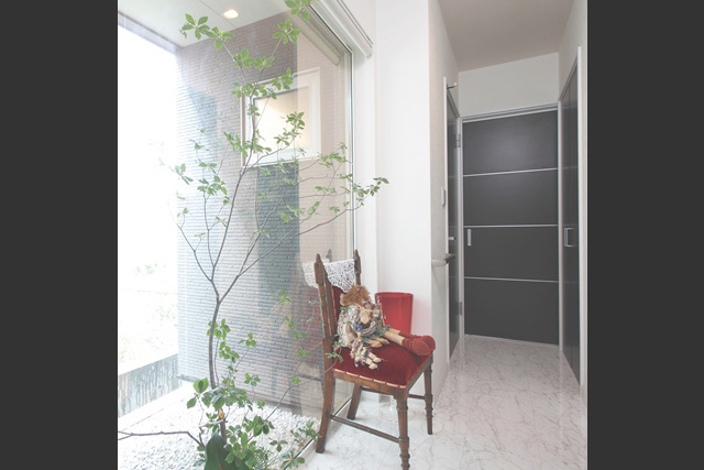 廊下： 玄関からユーティリティ、 キッチンへと続く廊下。 左手の窓からは坪庭が見えます。