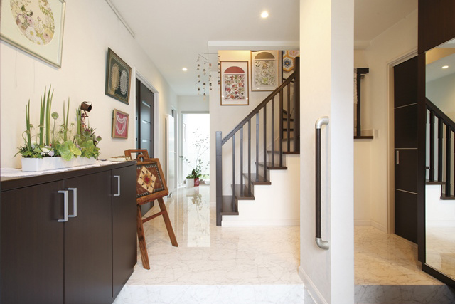 玄関： 明かるく広々とした玄関は、 好きな植物画などを飾る ギャラリースペースにもなっています。